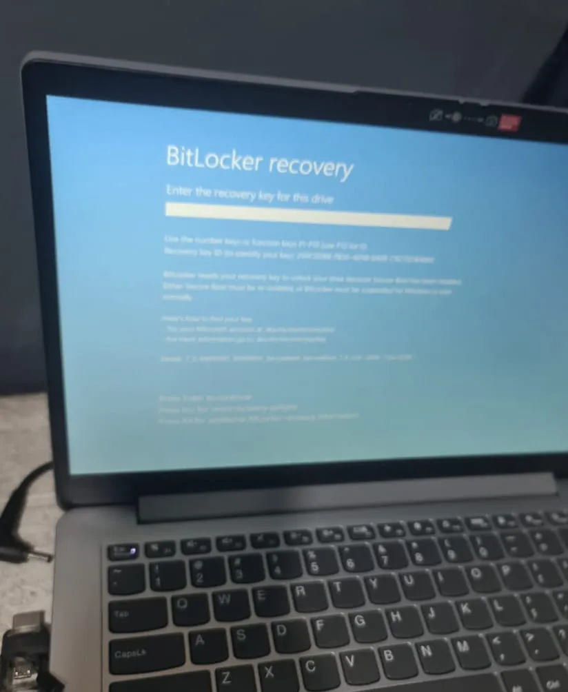 Laptop menampilkan layar BitLocker recovery berwarna biru yang meminta pengguna memasukkan recovery key untuk membuka drive."