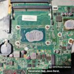 Kondisi motherboard laptop dengan prosesor terbuka dan thermal paste lama sebelum proses pembersihan dan penggantian, servis laptop di Beji Depok